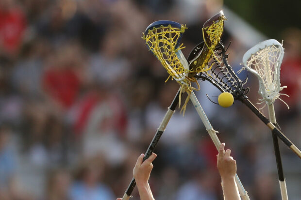Lacrosse players are reaching with their sticks to catch a ball during a game, HD Desktop Wallpaper