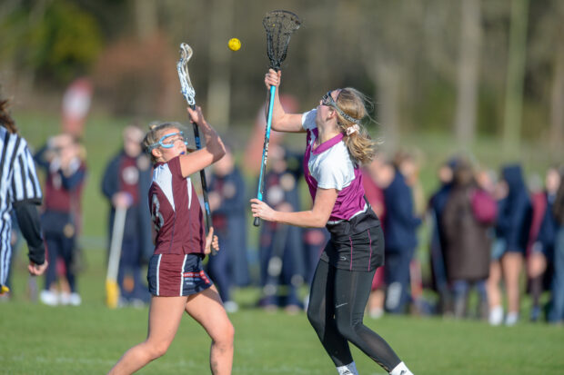 Two female lacrosse players compete fiercely for the ball during a match, HD Desktop Wallpaper