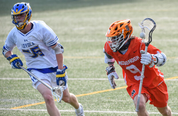 Two lacrosse players compete on the field wearing protective gear and holding lacrosse sticks, 2K Desktop Wallpaper