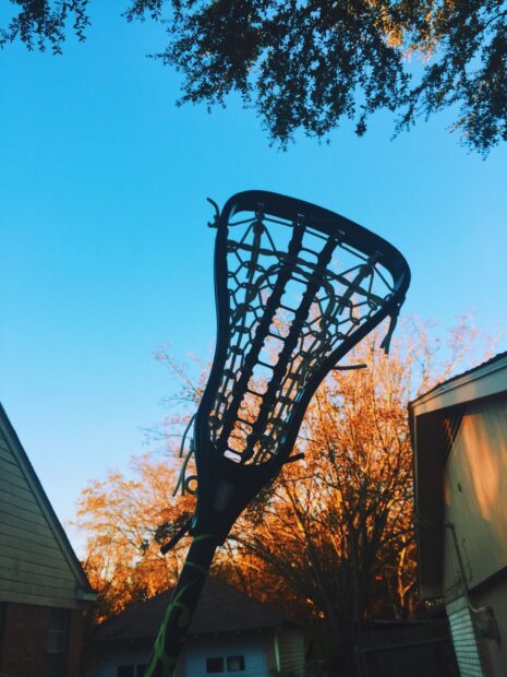 A lacrosse stick standing against a clear blue sky with autumn trees in the background, HD Mobile Wallpaper
