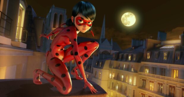 Ladybug hero character crouching on rooftop at night with moon and cityscape background