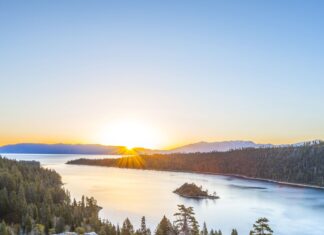 The sun rises over Lake Tahoe Emerald Bay surrounded by pine trees and mountains, HD Desktop Wallpaper