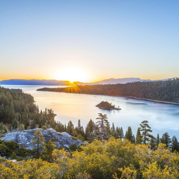 The sun rises over Lake Tahoe Emerald Bay surrounded by pine trees and mountains, HD Desktop Wallpaper