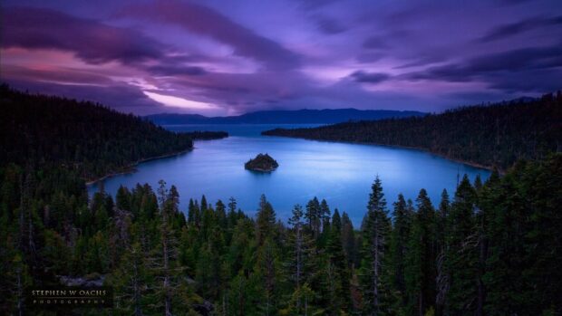 A tranquil view of Lake Tahoe Emerald Bay surrounded by pine trees under a purple sky, HD Desktop Wallpaper
