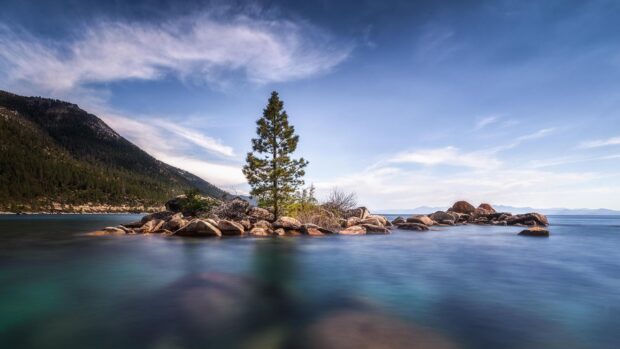 A peaceful view of Lake Tahoe Emerald Bay with clear water and rocky shore, 2K Desktop Wallpaper