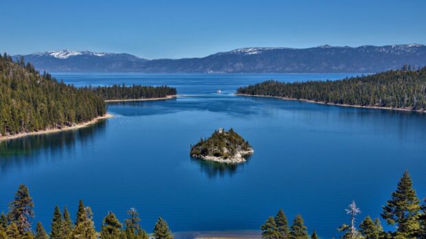 A peaceful view of Lake Tahoe Emerald Bay with clear blue water and surrounding pine trees, HD Desktop Wallpaper