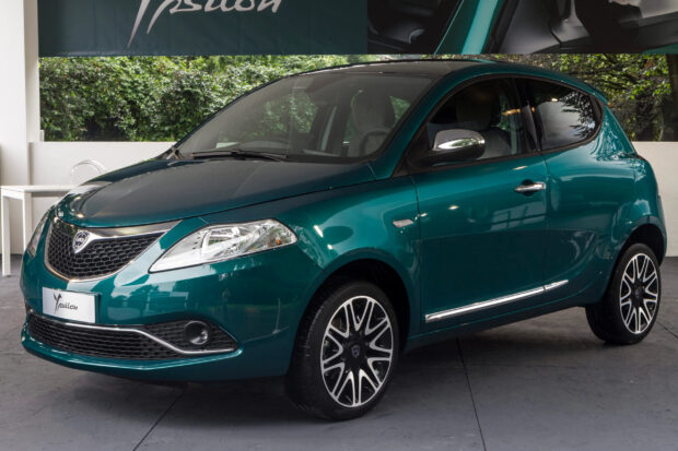 A green Lancia Ypsilon hatchback is parked indoors by a wall, 2K Desktop Wallpaper