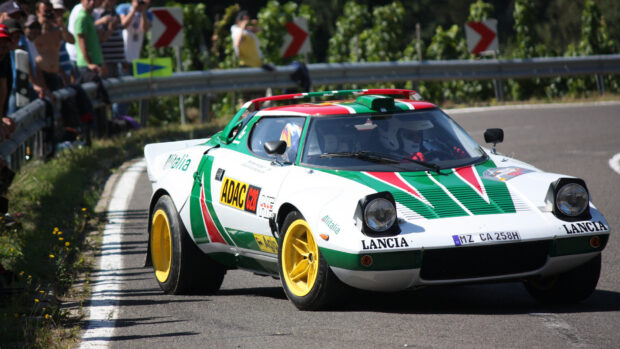 A Lancia car with green and red stripes takes a sharp turn on a race track, HD Desktop Wallpaper
