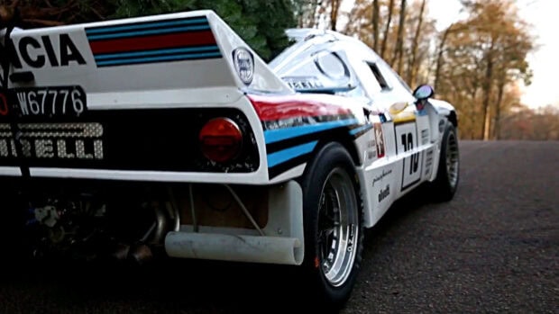 A close up view of a Lancia car with colorful racing stripes parked on a road, HD Desktop Wallpaper