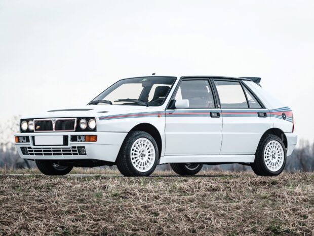 A white Lancia rally car parked on a field under a clear sky, HD Desktop Wallpaper