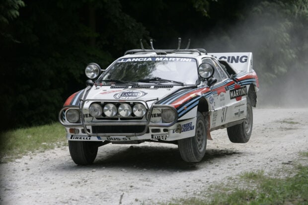A Lancia car is jumping on a gravel road during a race, HD Desktop Wallpaper