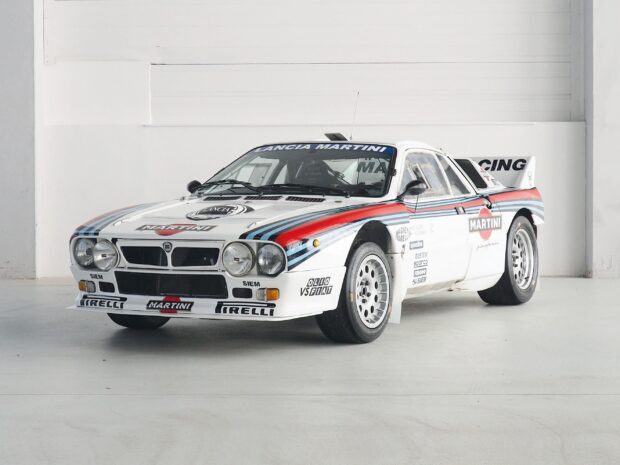 A white Lancia rally car with Martini racing stripes in a garage, 2K Desktop Wallpaper