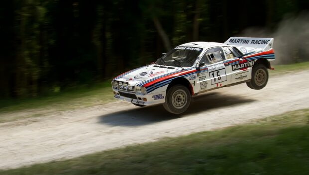 A Lancia rally car is captured speeding on a dirt road during a race, HD Desktop Wallpaper