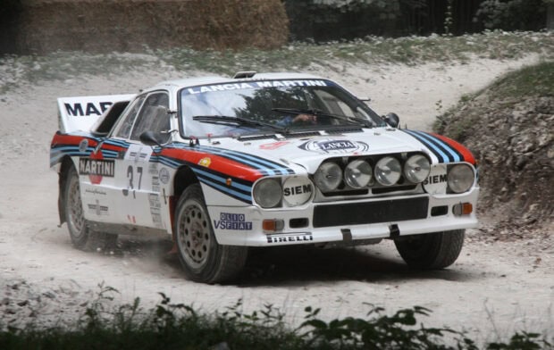 A Lancia rally car speeds on a dirt road during a race event, 2K Desktop Wallpaper