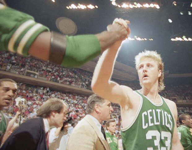 Larry Bird celebrates with a teammate in a green Celtics jersey during a basketball game, HD Desktop Wallpaper