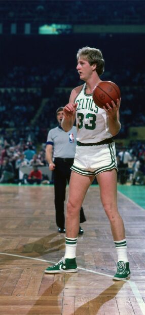 Larry Bird is focused on the court holding a basketball during a game, 2K Mobile Wallpaper