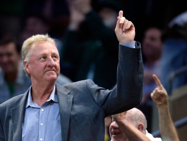 Larry Bird raising his hand during an event with people in the background, 2K Desktop Wallpaper