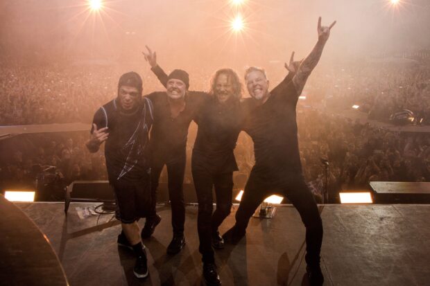 Lars Ulrich and his band stand together in front of a cheering crowd after a concert, 2K Desktop Wallpaper