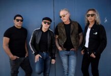 Bold and stylish group of four men wearing sunglasses, standing against a blue background, showcasing their cool fashion for a rock band or urban lifestyle.