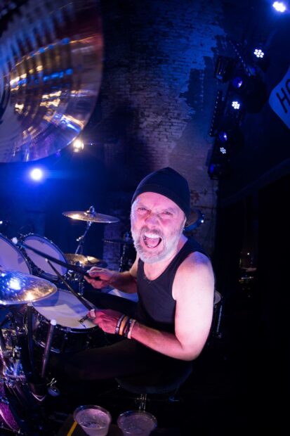 Lars Ulrich is performing energetically on stage with his drum set, HD Mobile Wallpaper