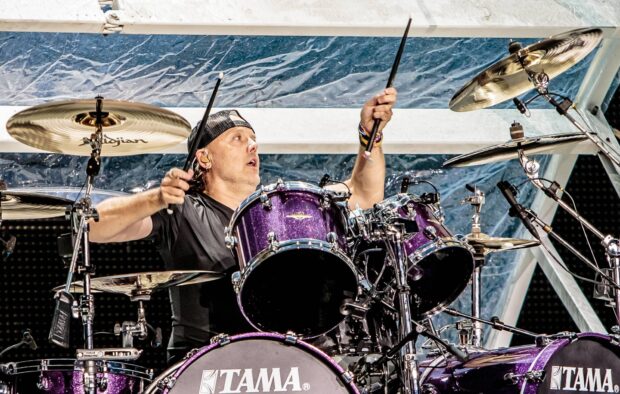 Lars Ulrich is captured playing drums with intense focus during a live performance, HD Desktop Wallpaper