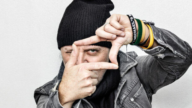 Lars Ulrich is making a hand frame gesture while wearing a beanie and bracelets, HD Desktop Wallpaper