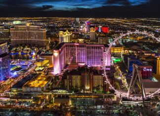 Las Vegas skyline at night with illuminated buildings and a large Ferris wheel