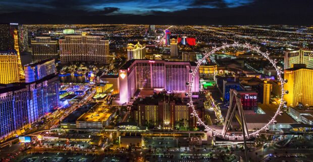 Las Vegas skyline at night with illuminated buildings and a large Ferris wheel