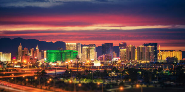 Las Vegas skyline at sunset with colorful city lights and mountain backdrop
