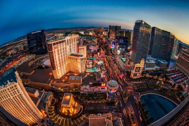 Las Vegas skyline with illuminated skyscrapers and bustling streets at dusk