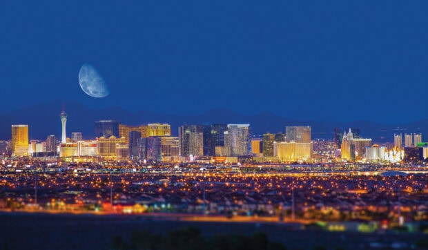 Night view of Las Vegas skyline with a large moon over the cityscape
