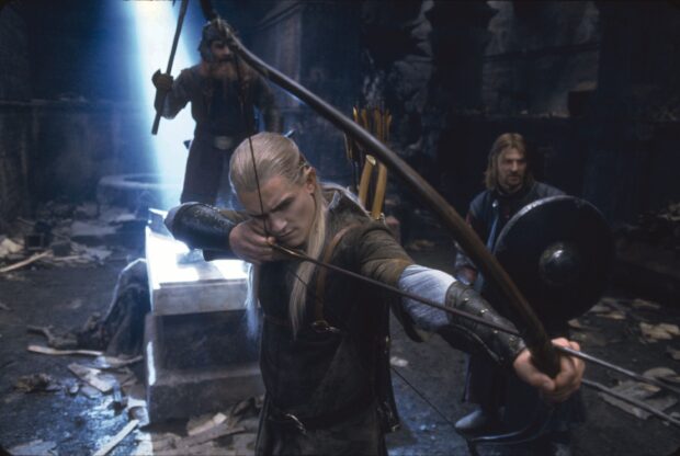 Legolas aiming his bow and arrow in a dark underground setting