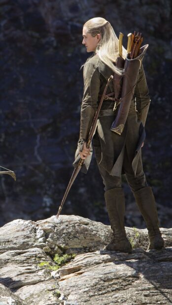 Legolas standing on a rock holding a bow and arrows in high definition