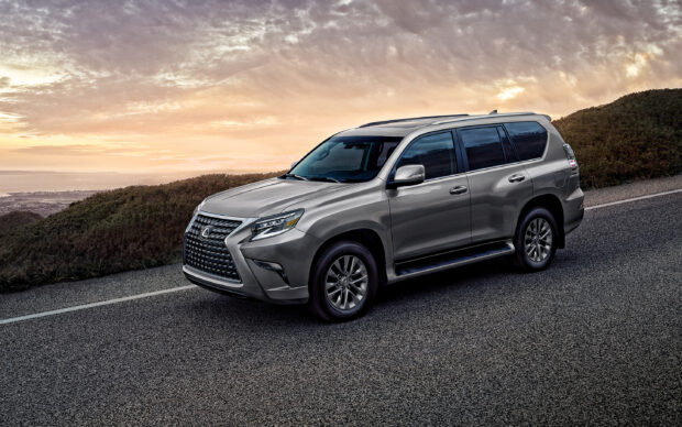 A Lexus GX SUV is parked on a mountain road with a scenic sunset sky behind, 2K Desktop Wallpaper