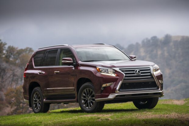 A maroon Lexus GX is parked on grass with a foggy mountainous background, 2K Desktop Wallpaper