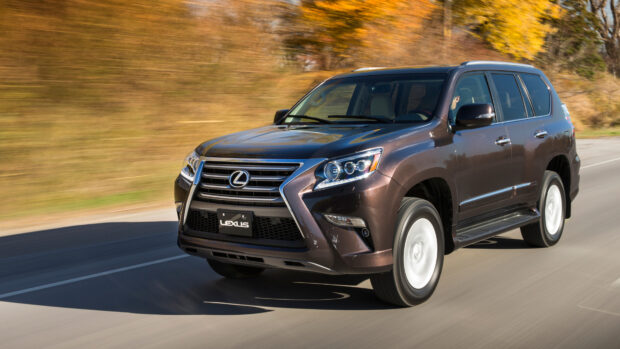 A Lexus GX is driving down a road surrounded by autumn foliage, 4K Desktop Wallpaper