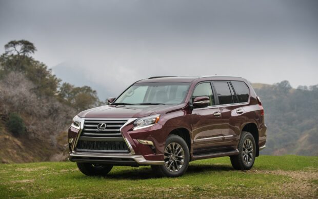 A burgundy Lexus GX is parked on green grass with mountains in the background, 2K Desktop Wallpaper