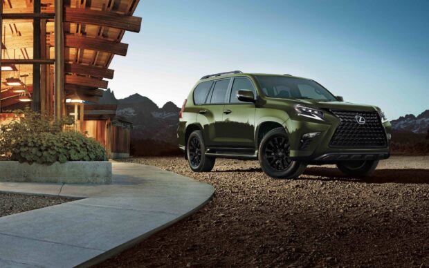 A green Lexus Gx is parked outdoors near a wooden building with mountains in the background, HD Desktop Wallpaper