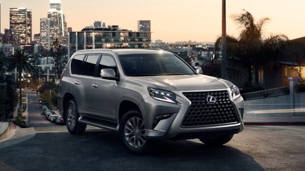 A Lexus GX vehicle parked on a city street at dusk with buildings in the background, HD Desktop Wallpaper