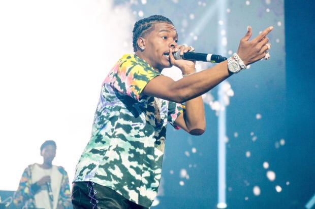 Lil Baby is performing energetically on stage during a live concert, HD Desktop Wallpaper