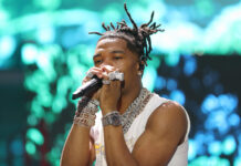 Lil Baby is performing on stage wearing multiple chains and rings, 2K Desktop Wallpaper