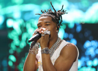 Lil Baby is performing on stage wearing multiple chains and rings, 2K Desktop Wallpaper