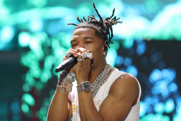 Lil Baby is performing on stage wearing multiple chains and rings, 2K Desktop Wallpaper