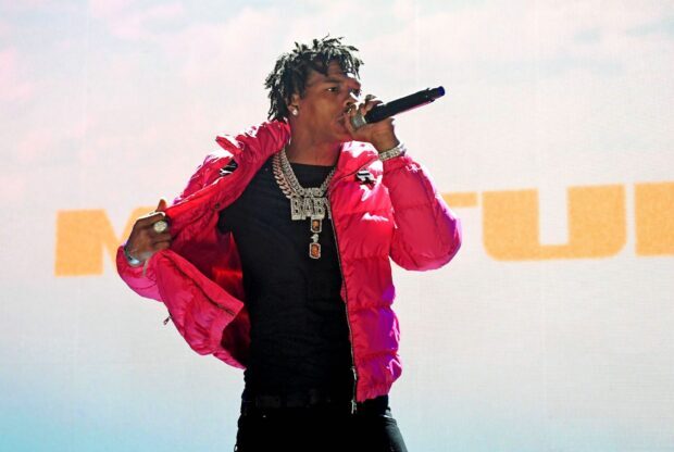Lil Baby is singing into a microphone wearing a red jacket and chains, HD Desktop Wallpaper