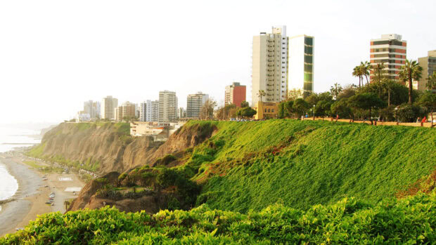 Lima Peru Wallpapers show a coastal city with tall buildings and lush cliffs along the shore, HD Desktop Wallpaper