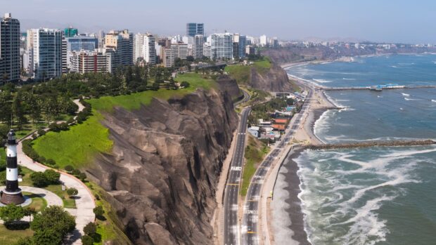 A scenic view of Lima Peru featuring cliffs, the ocean, and city buildings along the coast, 2K Desktop Wallpaper