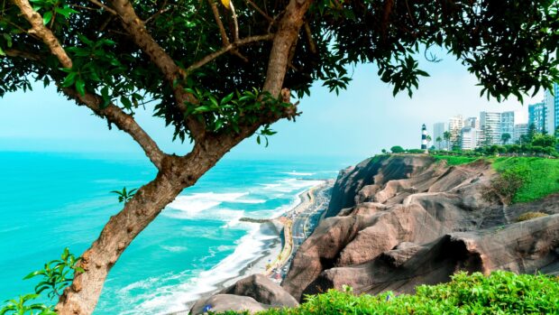 The coastal cliffs and lighthouse tower overlook the turquoise ocean in Lima Peru, 4K Desktop Wallpaper