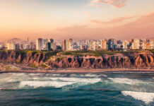 The Lima Peru skyline shows tall buildings along the coast with waves crashing on the shore, HD Desktop Wallpaper