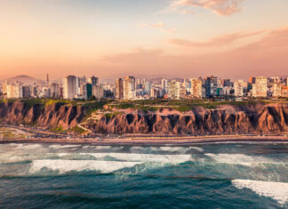 The Lima Peru skyline shows tall buildings along the coast with waves crashing on the shore, HD Desktop Wallpaper