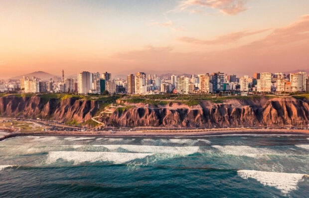 The Lima Peru skyline shows tall buildings along the coast with waves crashing on the shore, HD Desktop Wallpaper